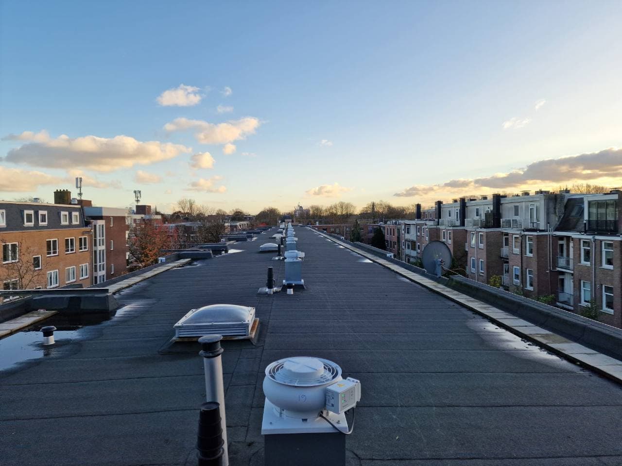 Rij vernieuwde dakventilatoren op een wooncomplex in Amsterdam